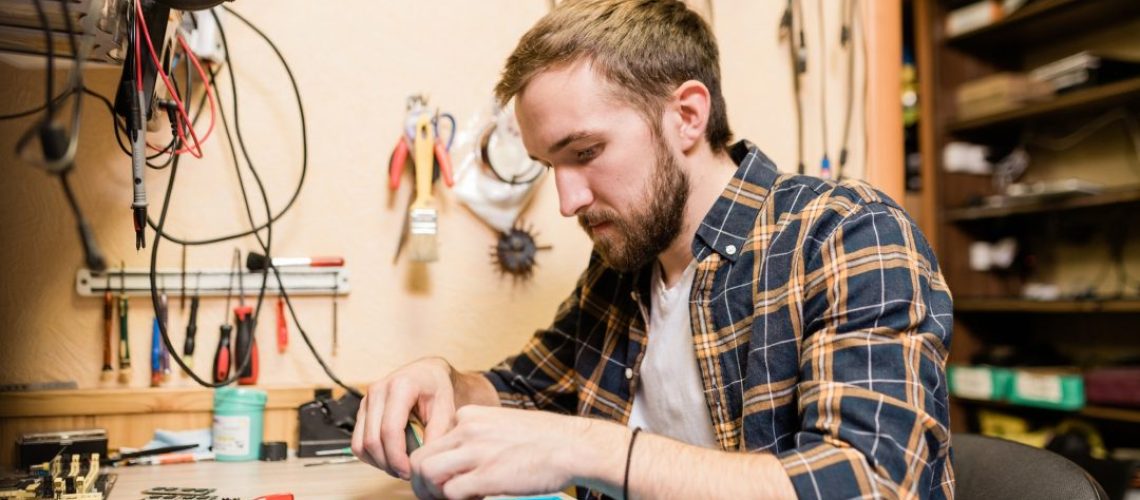 professional-repairman-bending-over-broken-smartphone-and-fixing-tiny-details-1.jpg